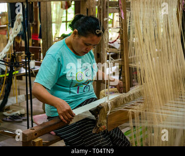 Lavoratore di sesso femminile che lavora su tessuto di tessitura a telaio, Ock Pop Tok workshop di tessitura, Luang Prabang, Laos, Asia Foto Stock