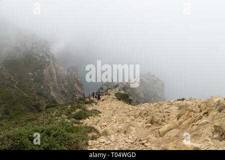 CABO DA ROCA, Portogallo - 2 Settembre 2018: turisti su Capo Roca scogliere nella nebbia. Le rocce sono oscurata da nuvole o nebbia. Capo Roca è più a ovest par Foto Stock