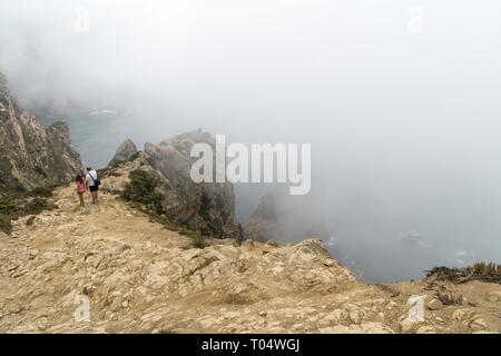 CABO DA ROCA, Portogallo - 2 Settembre 2018: turisti su Capo Roca scogliere nella nebbia. Le rocce sono oscurata da nuvole o nebbia. Capo Roca è più a ovest par Foto Stock