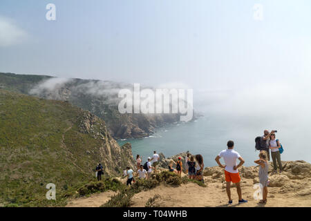 CABO DA ROCA, Portogallo - 2 Settembre 2018: turisti su Capo Roca scogliere nella nebbia. Le rocce sono oscurata da nuvole o nebbia. Capo Roca è più a ovest par Foto Stock