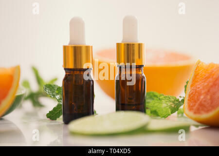 Organici cosmetici con estratti di erbe di limone, arancio, menta su sfondo lucido Foto Stock