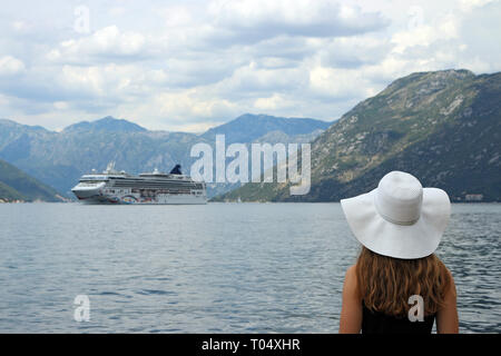 La ragazza guarda la nave da crociera di entrare nella Baia di Kotor stagione estiva Foto Stock