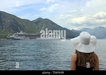 La ragazza guarda la nave da crociera di entrare nella Baia di Kotor Foto Stock