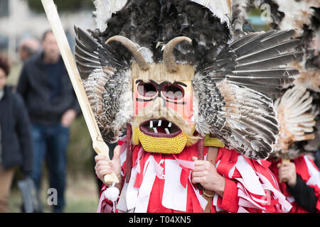 Zenen, Bulgaria - 16 Marzo 2019: Masquerade festival in Zemen, Bulgaria. Persone con maschera chiamata Kukeri danza e eseguire per spaventare gli spiriti maligni. Foto Stock