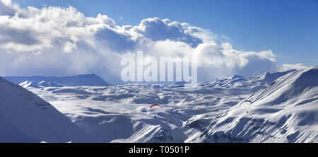 Velocità di volo nel sole montagne d'inverno. Innevate montagne del Caucaso alla sera. La Georgia, regione Gudauri. Vista panoramica. Foto Stock