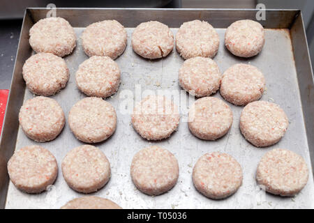 Closeup preparazione delle costolette di pollo per gli hamburger. Briciole di pane e burro sul metallo tavolo da cucina. Ingredienti. Concetto ristorante business, Foto Stock