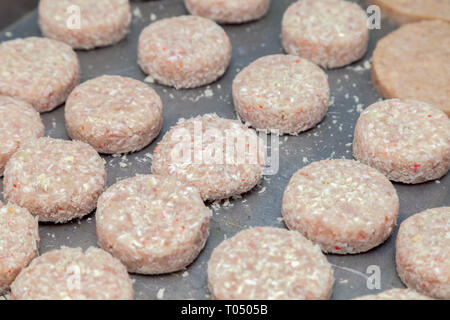 Closeup preparazione delle costolette di pollo per gli hamburger. Briciole di pane e burro sul metallo tavolo da cucina. Ingredienti. Concetto ristorante business, Foto Stock