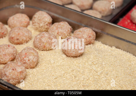 Closeup preparazione delle costolette di pollo per gli hamburger. Briciole di pane e burro sul metallo tavolo da cucina. Ingredienti. Concetto ristorante business, Foto Stock