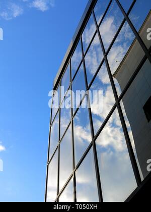 La riflessione di nuvole su vetri di finestre di un edificio. Foto Stock