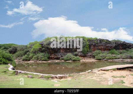 Piccola piscina di acqua di overflow dalla laguna Inarajan delimitata da pareti rocciose a Inarahan villaggio sulla costa sud-orientale di Guam Foto Stock