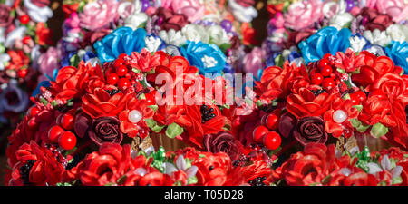 Composizione di piccoli fiori fatti a mano, e rosso borgogna roses, perle, foglie verdi Foto Stock
