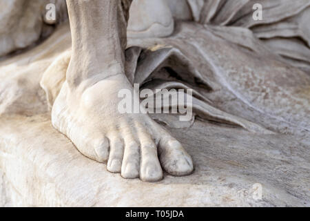 Parte della gamba di antica statua in marmo. Close-up piede di pietra. Pedicure e cura dei piedi del concetto. Foto Stock