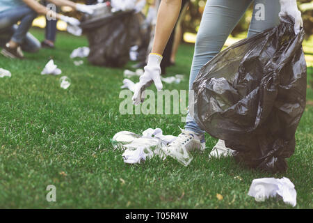 I giovani volontari la raccolta di rifiuti nel parco suumer Foto Stock