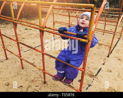 Bambino salendo sulla scaletta a parco giochi Foto Stock