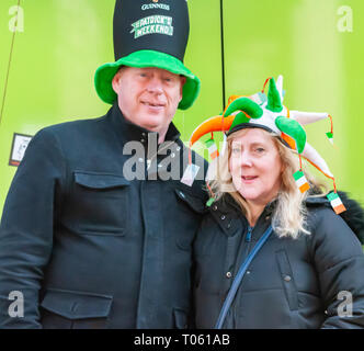 Glasgow, Scotland, Regno Unito. 17 Marzo 2019: un uomo che indossa un cappello alto e una donna che indossa un verde, bianco e oro hat celebrare la festa di San Patrizio in città. Credito: Berretto Alamy/Live News Foto Stock