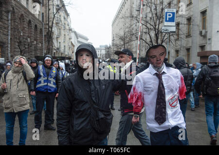 Kiev, Ucraina. 16 Mar, 2019. Un manifestante mascherato visto tenendo un manichino con la faccia di oligarch Oleg Gladkovsky durante la dimostrazione.Migliaia di persone si è trasformata in segno di protesta contro la corruzione in seno ai militari e forze di polizia sotto la presidenza di Petro Poroshenko chi è alto per la riflessione alla fine di marzo. Credito: Matteo Hatcher/SOPA Immagini/ZUMA filo/Alamy Live News Foto Stock
