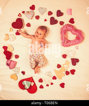 Piacevole timespending. L'amore. Ritratto di felice piccolo bambino. Sweet Little baby. La vita nuova e la nascita. La famiglia. Prodotti per la cura del bambino. Piccola ragazza tra i cuori rossi Foto Stock