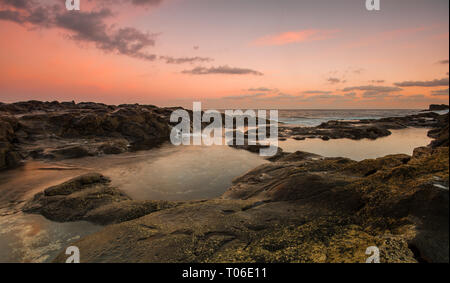 Una lunga esposizione sunrise e colorati di cielo, roccia vulcanica bellissimo paesaggio marino a Gran Canaria Island Costa in Spagna. Foto Stock