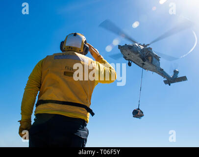 190316-N-HD110-0200 OCEANO PACIFICO (16 marzo 2019) di Boatswain Mate 2a classe John Robert Davis Jr. saluta il pilota di un MH-60S Sea Hawk elicottero, attaccato al mare in elicottero Combat Squadron (HSC) 21 come esso si diparte la harpers Ferry-classe dock anfibio sbarco nave USS harpers Ferry (LSD 49). Harpers Ferry è in corso conducendo le operazioni di routine come una parte di USS Boxer anfibio gruppo pronto (ARG) nell'Oceano Pacifico orientale. (U.S. Foto di Marina di Massa lo specialista di comunicazione di terza classe Danielle A. Baker) Foto Stock