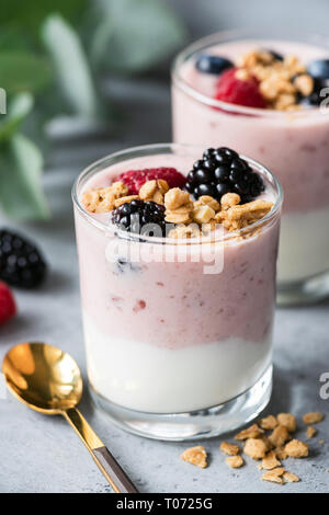 Il greco Yogurt alla frutta con frutti di bosco, granola su cemento Tabella. Cibo sano Foto Stock