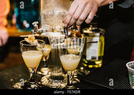 Un barman preparazione di cocktail miscelati con assenzio a un evento Foto Stock