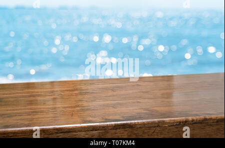 Vuoto marrone legno lucido tavolo con sfocatura del cielo e del mare sullo sfondo boekh,banner mock up modello per la visualizzazione del prodotto Foto Stock