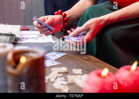 Close up di fortune-teller indossando un bracciale azienda CARTE DA DIVINAZIONE Foto Stock