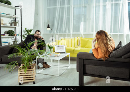 Serio professionista barbuto ascolto al suo visitatore Foto Stock