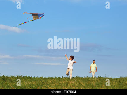 Padre e figlio giocare con un aquilone in natura. Foto Stock