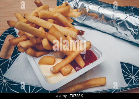 Vista ravvicinata di calde appena fatte le patatine fritte su un vassoio con tovaglioli Foto Stock