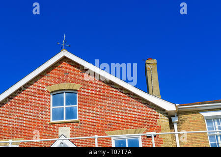 In prossimità del raccolto di un inglese casa in mattoni rossi contro un cielo blu senza nuvole Foto Stock