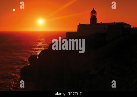 Romantico tramonto a costa rocciosa con il faro Foto Stock