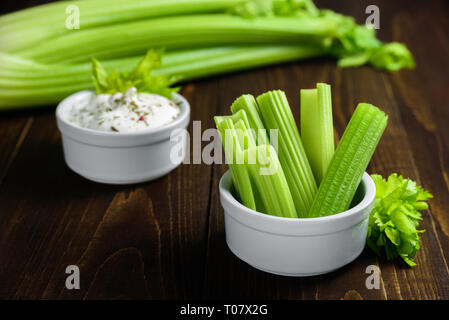 Coste di sedano in vaso di ceramica greca con salsa di yogurt Foto Stock