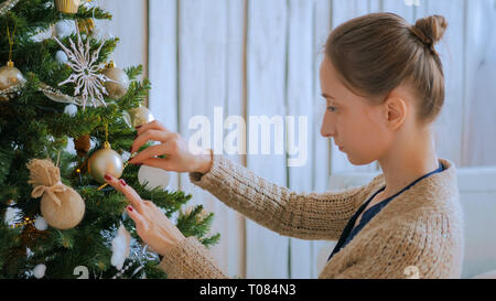 Donna decorazione di albero di Natale con i giocattoli Foto Stock