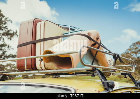 Pila di sacchi vintage e arto artificiale sul tetto della vettura fissata con fune Foto Stock
