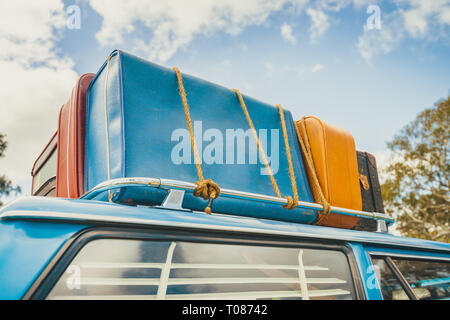 Pila di sacchi vintage sul tetto della vettura di viaggio fissata con fune Foto Stock