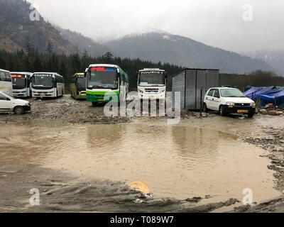 MANALI, HIMACHAL PRADESH—2018 MARZO: Gli autobus di trasporto si fermano in un terminal fangoso in una giornata piovosa a Manali. Foto Stock