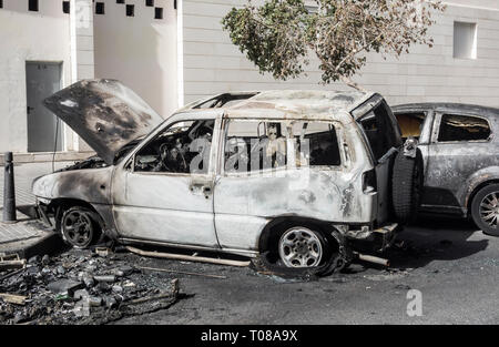 Bruciato automobili che erano parcheggiate accanto al contenitore di rifiuti incendiata dai vandali in strada in Spagna Foto Stock