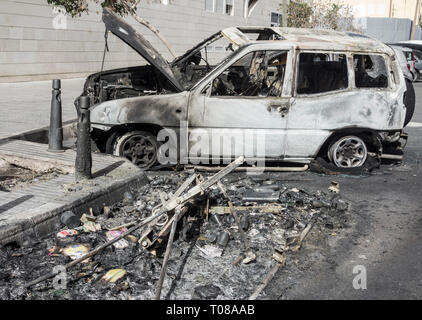 Bruciato automobili che erano parcheggiate accanto al contenitore di rifiuti incendiata dai vandali in strada in Spagna Foto Stock