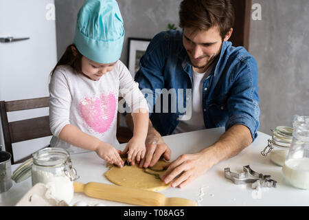 Padre e figlia piccola pasticceria da forno. Famiglia divertimento in cucina e tenetevi pronti per una festa. Foto Stock