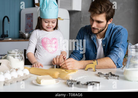 Padre e figlia piccola pasticceria da forno. Famiglia divertimento in cucina e tenetevi pronti per una festa. Foto Stock