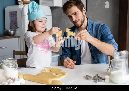 Padre e figlia piccola pasticceria da forno. Famiglia divertimento in cucina e tenetevi pronti per una festa. Foto Stock