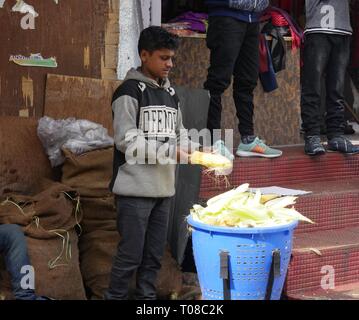 MANALI, HIMACHAL PRADESH, INDIA--MARZO 2018: Un uomo vende le bucce di mais appena raccolto da un lato della strada a Manali. Foto Stock