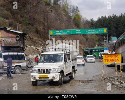 MANALI, HIMACHAL PRADESH—2018 MARZO: Strada larga sparata con auto che viaggiano sulla strada fangosa per Manali in una mattina piovosa. Foto Stock