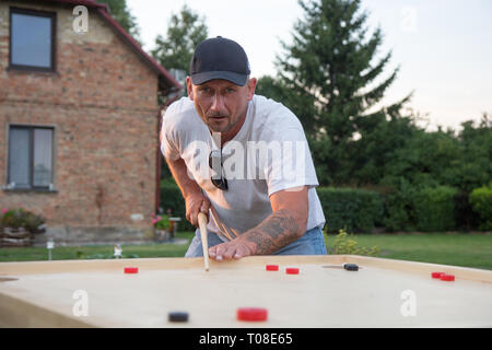 L'uomo gioca Novuss in all'aperto Foto Stock