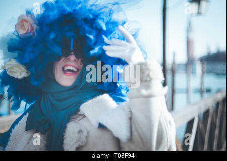 Donna mascherata con un blu piume hat durante il carnevale di Venezia Foto Stock