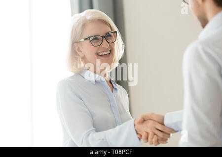 Felice coppia imprenditrice di handshaking client partner, di fiducia e di gratitudine handshake Foto Stock