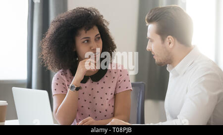 Diversi colleghi parlare in ufficio a lavorare con il computer portatile condividere idee Foto Stock