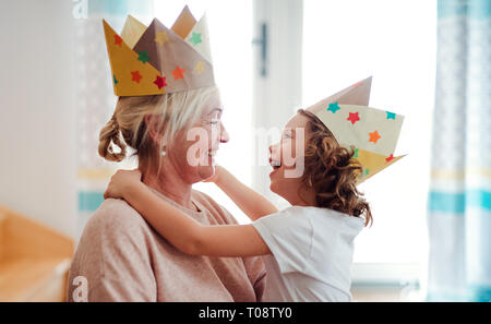 Un ritratto della bambina con la nonna avente il divertimento a casa. Foto Stock