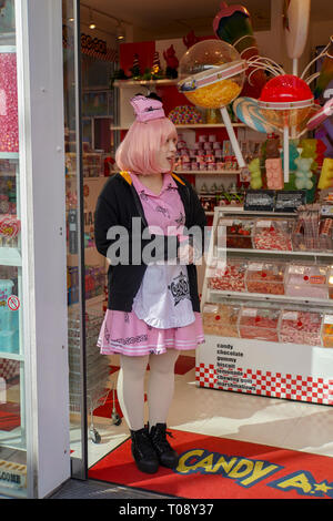 Ragazza in rosa uniforme di vendita di caramelle, Takeshita Street, Harajuku, Tokyo, Giappone Foto Stock